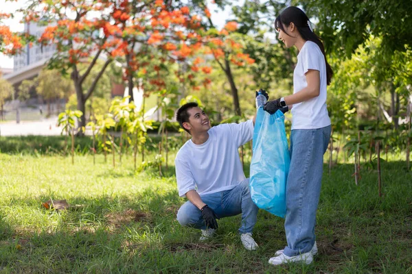 stock image Happy young Asian students diverse volunteers with garbage bags cleaning area in the park, The concept of environmental conservation on world environment day, recycling, charity for sustainability.