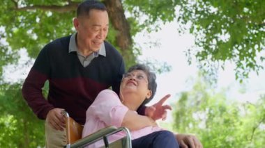 Yaşlı çiftler ya da bakıcılar tekerlekli sandalyedeki hastalarla ilgilenir. Bakıcının, birikimin ve sağlık sigortasının özenle mutlu bir emeklilik kavramı. Mutlu bir aile.