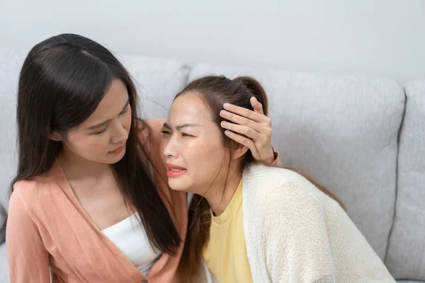 Two women talking about problems at home. Asian women embrace to calm their sad best friends from feeling down. Female friends supporting each other. Problems, friendship, and care concept