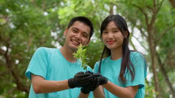 アジアのボランティアのグループは 一緒に環境を回復するために木の苗を植えています 公園内のリサイクル用ボランティアクリーニングパークやゴミ収集 社会的責任の概念 — ストック動画