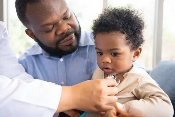 Pediatrics doctor with stethoscope for lungs or chest checkup for examining cute little girl in medical healthcare hospital or clinic. Doctor check Heart And Lungs for Smiling African American Baby.