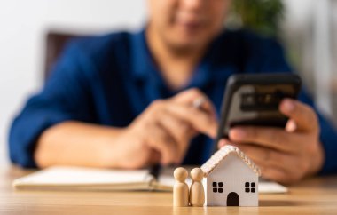 İşadamı, emlak sigortası, emlak komisyoncusu ya da ev sigortası için akıllı telefon bulundurur. Ev sigortası sözleşmesi. konut kredisi kavramı, bankacılık kredi borç ödemesi planlama.