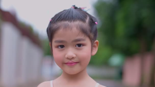 Çekici Bir Asyalı Kızın Portresi Gülümseyip Kameraya Bakıyor Elini Sallıyor — Stok video