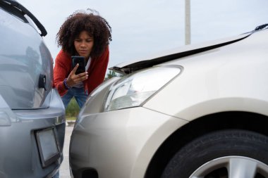 Yarı Taylandlı Afrikalı sürücü, fotoğraf çekip sigorta göndermeden önce araba kazasından sonra hasar kontrolü yapmış. Çevrimiçi trafik kazası sigorta talebi. Fotoğrafları ve kanıtları sigortaya gönderdikten sonra..