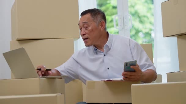 Asijské Starší Pomocí Notebooku Smartphonu Pro Kontrolu Mailové Objednávky Domácí — Stock video