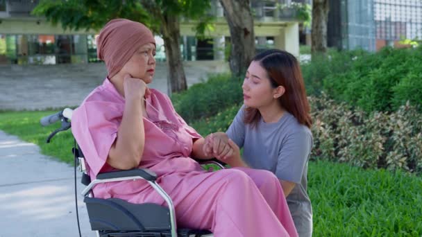 亚洲细心的护理人员或护士和患癌症的妇女正坐在轮椅上 在花园里 在照料者 储蓄和老年健康保险的照料下快乐退休的概念 — 图库视频影像