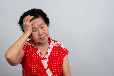 Bunalımlı Asyalı son sınıf öğrencisi kadın, yalnız, beyaz arka planda hayal kırıklığına uğramış ve hafızasını kaybetmiş. Yaşlı kadının portresi hasta depresyon hastalığı üzgün ve mutsuz, bunama, sağlık sorunları konsepti.