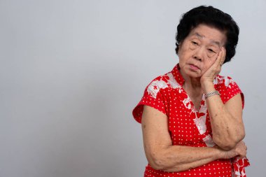 Bunalımlı Asyalı son sınıf öğrencisi kadın, yalnız, beyaz arka planda hayal kırıklığına uğramış ve hafızasını kaybetmiş. Yaşlı kadının portresi hasta depresyon hastalığı üzgün ve mutsuz, bunama, sağlık sorunları konsepti.