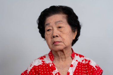 Bunalımlı Asyalı son sınıf öğrencisi kadın, yalnız, beyaz arka planda hayal kırıklığına uğramış ve hafızasını kaybetmiş. Yaşlı kadının portresi hasta depresyon hastalığı üzgün ve mutsuz, bunama, sağlık sorunları konsepti.