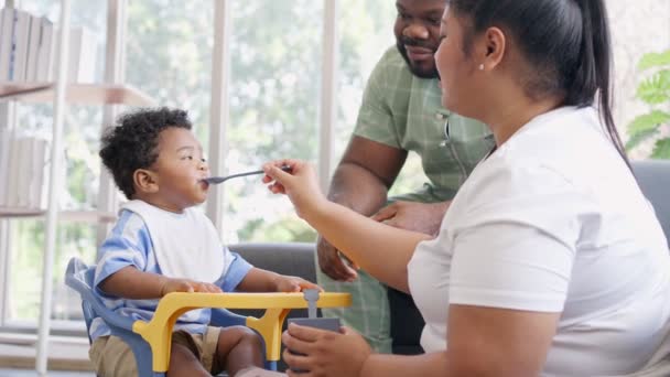 아시아 엄마는 개월된 귀여운 아기와 아프리카 미국인에게 집에서 접시를 있습니다 — 비디오