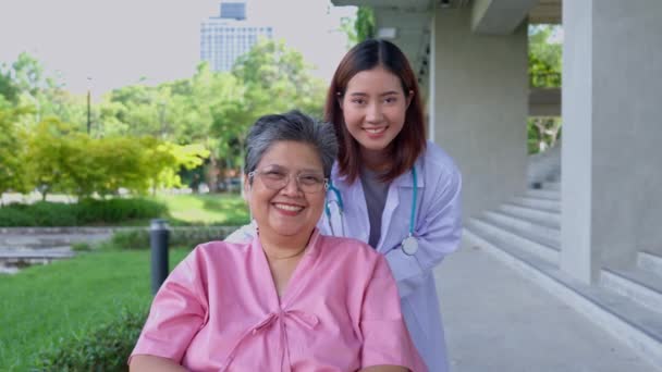 アジアの慎重な介護者または医師は 患者手を握り 車椅子で患者を奨励する 介護者 高齢者健康保険によるハッピーリタイアのコンセプト — ストック動画