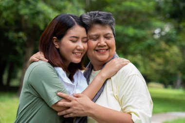 Parkta sabah egzersizinde birlikte çalışan çekici bir anne ve kız çocuğu. Kız konuşur, gülümser ve annesiyle güler. Üst düzey bir bakıcı ve mutlu bir aile kavramı..