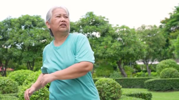 老年妇女在室外体育场慢跑 老年女性在夏天散步或跑步时 为有氧运动促进健康和健康而感到高兴 促进健康的保健和积极生活方式的概念 — 图库视频影像