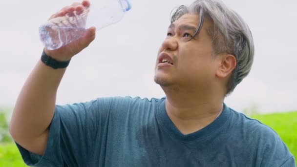 Азиатский Мужчина Среднего Возраста Брызгает Наливает Пьет Свежую Воду Бутылки — стоковое видео