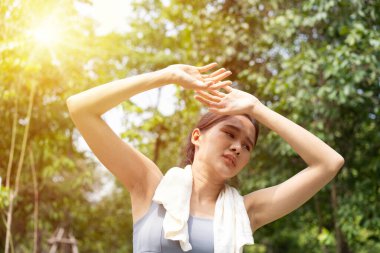 Spor yapan Asyalı kadın yorulur ve başı döner, kötü bir ağrı hisseder ve yaz mevsiminde dışarıda koşarken ya da dışarıda güçlü güneş ışığı ile egzersiz yaparken dışarıda acı çeker. Sıcak çarpması ve sıcak hava dalgası kavramı.