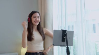 Asyalı kadınlar ve güzel blogcular akıllı telefon kameralarıyla kulaklık takıp dans ediyorlar. Yaratıcı vlogger yetenek dansı, sosyal medyada hobi içeriği kayıt programı paylaşımından keyif alıyor.