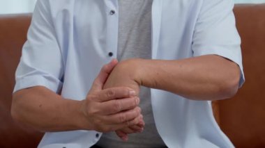 Yaşlı Asyalı erkek hastalar romatizma eklem iltihabından ellerindeki uyuşma ağrısından muzdarip. Son sınıflar eline bilek ağrısıyla masaj yapıyor. Eklem ağrısı, romatizma eklem iltihabı ve el sorunları..