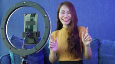 Mutlu genç Asyalı kadınlar güzel blogcular sosyal medya uygulamaları için kulaklık ve video kayıt kullanıyorlar. Özgürlük ve aktif yaşam tarzı konsepti, canlı video üzerinden satışları iletin.