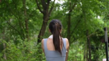 Asyalı kadınlar parka koşmaya gitmeden önce kaslarını esnetiyorlar, gülümseyen spor yapan kadın esneme ve egzersiz yapıyor, sağlıklı bir yaşam tarzı, gülümseyen spor kadını.