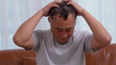Bunalımlı Asyalı son sınıf öğrencisi evde oturma odasında hayal kırıklığına uğradı ve hafızasını kaybetti. Yaşlı adamın portresi hasta depresyon hastalığı üzgün ve mutsuz, bunama, sağlık sorunları konsepti.