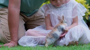 Büyükbaba ve torun Bunny ile bağ kuruyor, jenerasyonlar arası bağın iç açıcı bir sahnesi, büyükbabasının torununa nazikçe bir bebek tavşan göstermesi, aile bağları..