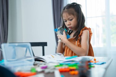 Genç Mühendisler: çok ırklı çocuklar, küçük robotik üretimi, merak göstergesi, takım çalışması ve erken STEM eğitimine odaklanmış durumdalar. Odaklanan robot ve çocuklar çarpışmaya hazırlanıyor..