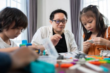 Çok ırklı çocuklar, öğretmenle birlikte küçük robotlar yapma ve test etme, merakı, takım çalışması ve erken STEM eğitimine odaklanmış durumdalar. Odaklanan robot ve çocuklar çarpışmaya hazırlanıyor..