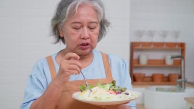 İki yaşlı kadın dostça bir yemek hazırlıyor, taze malzemelerle lezzetli bir yemek hazırlıyor ve birbirlerinin keyfini çıkarıyorlar, evlerinde keyifli bir aşçılık deneyimi yaşıyorlar.