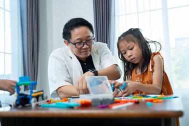 Çok ırklı çocuklar, öğretmenle birlikte küçük robotlar yapma ve test etme, merakı, takım çalışması ve erken STEM eğitimine odaklanmış durumdalar. Odaklanan robot ve çocuklar çarpışmaya hazırlanıyor..