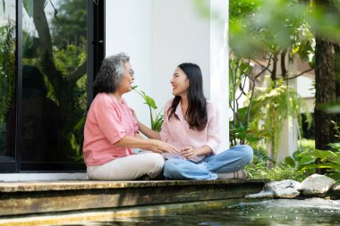 Kızları ve yaşlı anneleri, aile bağlarını güçlendirmek için samimi bir anı paylaşıyorlar. Bakıcı, sevgi ve destek sunuyor. İlişkilerini ve paylaşmanın güzelliğini vurguluyor.