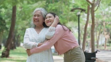 Gülümseyen bir kız, dışarıda annesine destek olur, neşeyi paylaşır ve aile bağlarını güçlendirir. İlişkileri derin bir özen ve duyguyu yansıtıyor. Emeklilik yolculuğunu sevgiyle kucaklıyor.