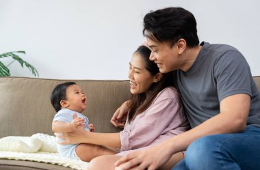 Sevgi dolu bir ebeveyn bebeğini kucaklar, sıcaklığını ve masumiyetini derin bir bağ anında paylaşır. Bu mutlu aile ebeveynliğe değer veriyor, ebeveynliğin güzelliği ile ilişkilerini güçlendiriyor.