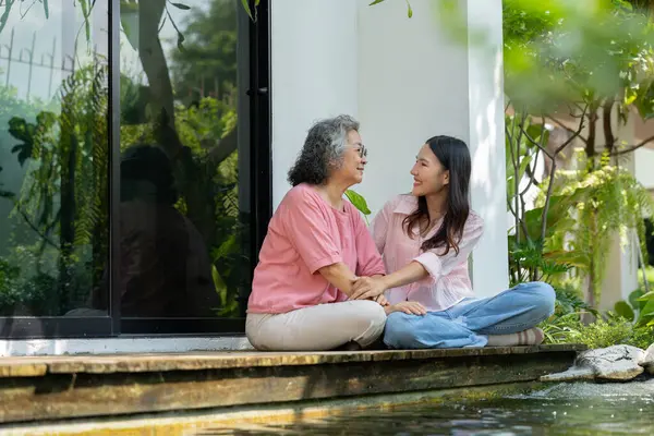 Kızları ve yaşlı anneleri, aile bağlarını güçlendirmek için samimi bir anı paylaşıyorlar. Bakıcı, sevgi ve destek sunuyor. İlişkilerini ve paylaşmanın güzelliğini vurguluyor.