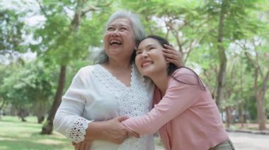 Gülümseyen bir kız, dışarıda annesine destek olur, neşeyi paylaşır ve aile bağlarını güçlendirir. İlişkileri derin bir özen ve duyguyu yansıtıyor. Emeklilik yolculuğunu sevgiyle kucaklıyor.