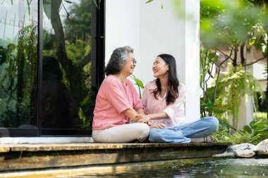 Kızları ve yaşlı anneleri, aile bağlarını güçlendirmek için samimi bir anı paylaşıyorlar. Bakıcı, sevgi ve destek sunuyor. İlişkilerini ve paylaşmanın güzelliğini vurguluyor.