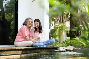 Kızları ve yaşlı anneleri, aile bağlarını güçlendirmek için samimi bir anı paylaşıyorlar. Bakıcı, sevgi ve destek sunuyor. İlişkilerini ve paylaşmanın güzelliğini vurguluyor.