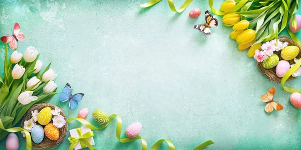 イースターの背景 蝶とヴィンテージボード上の絵の卵とカラフルな春のチューリップ — ストック写真