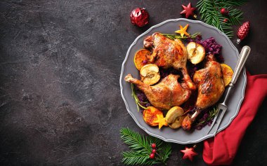 Elma, portakal ve baharatla kızartılmış ördek bacakları ve Noel süslemeleri. Noel zamanı yemek pişirmek