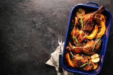 Elma, portakal ve kabak dilimleriyle kızartılmış ördek bacakları. Noel zamanı yemek pişirmek