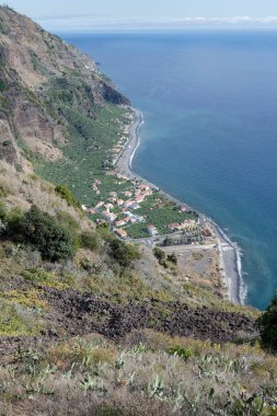 Portekiz, Ponta do Sol 'da parlak sonbahar ışığı altında çekilen Madeira adasındaki dik güney Atlantik kıyısı manzarası.