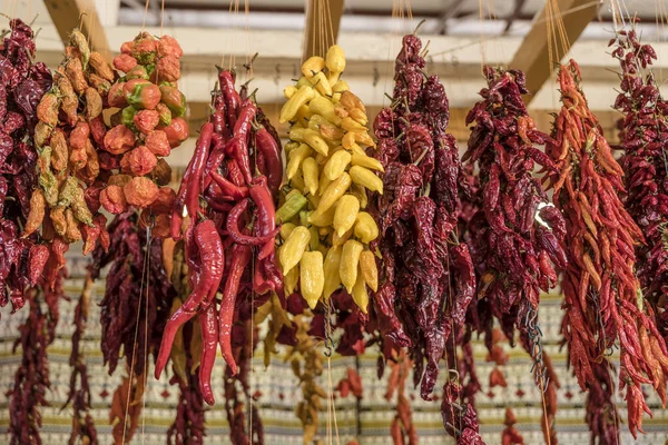 Renkli turuncu, sarı ve kırmızı biberler kapalı pazarda indirimde, Funchal, Madeira, Portekiz 'de parlak sonbahar ışığı altında çekiliyor.