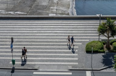 FUNCHAL, 2022 Ekim, tarihi kentin kıyı şeridinde yürüyen insanlarla dolu şehir manzarası, 11 Ekim 2022 'de Funchal, Madeira, Portekiz' de parlak bir sonbahar ışığı altında çekildi.