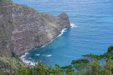 Faial 'ın batısındaki Atlantik Okyanus Koyu kıyısında dik volkanik kayalıkları olan manzara, Portekiz, Madeira' da açık bulutlu bir sonbahar ışığı altında çekilmiştir.