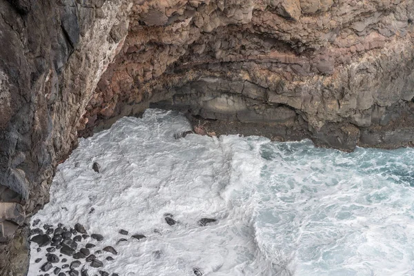 Madeira adasındaki okyanus dalgaları köpüklü ve volkanik kayalıklarla kaplı manzara, Fortim do Faial, Portekiz 'de parlak sonbahar ışığı altında çekilmiştir.