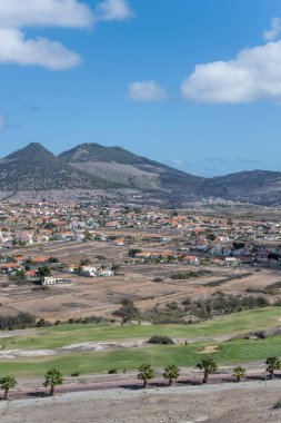 Yeşil golf sahası ve çorak adadaki köy Portekiz 'in Porto Santo adasında parlak bir sonbahar ışığı altında çekildi.