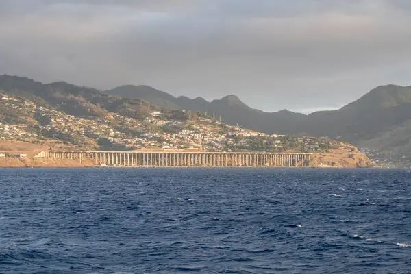 urban sprawl and airport bridge runway on shore at Madeira island, shot in bright dawn fall light at  Santa Cruz, Portugal