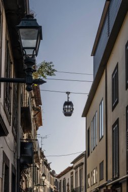 Eski kasabadaki dar sokaklar üzerinde kablo taksi ile şehir manzarası, Funchal, Madeira, Portekiz 'de parlak sonbahar ışığında çekilen