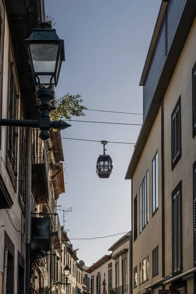 stock image cityscape with cableway cab over narrow street in old town, shot in bright fall light at Funchal, Madeira, Portugal