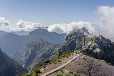 Verimsiz yamaçlarda, Areeiro tepesinin kuzeyindeki bulutların arasından yükselen manzara, zirveden parlak bir sonbahar ışığı altında çekildi, Madeira, Portekiz