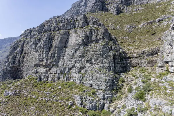 Masa Dağı 'nın doğu yamaçlarındaki dik kayalık kayalıklarla kaplı manzara Cape Town, Batı Burnu, Güney Afrika' da parlak yaz ışığında çekilmiştir.